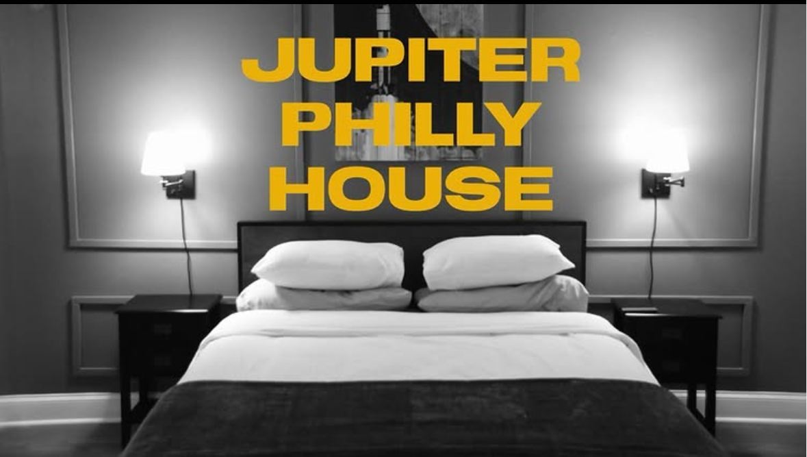 Jupiter Philly House bedroom in black and white with gold house name over the bed