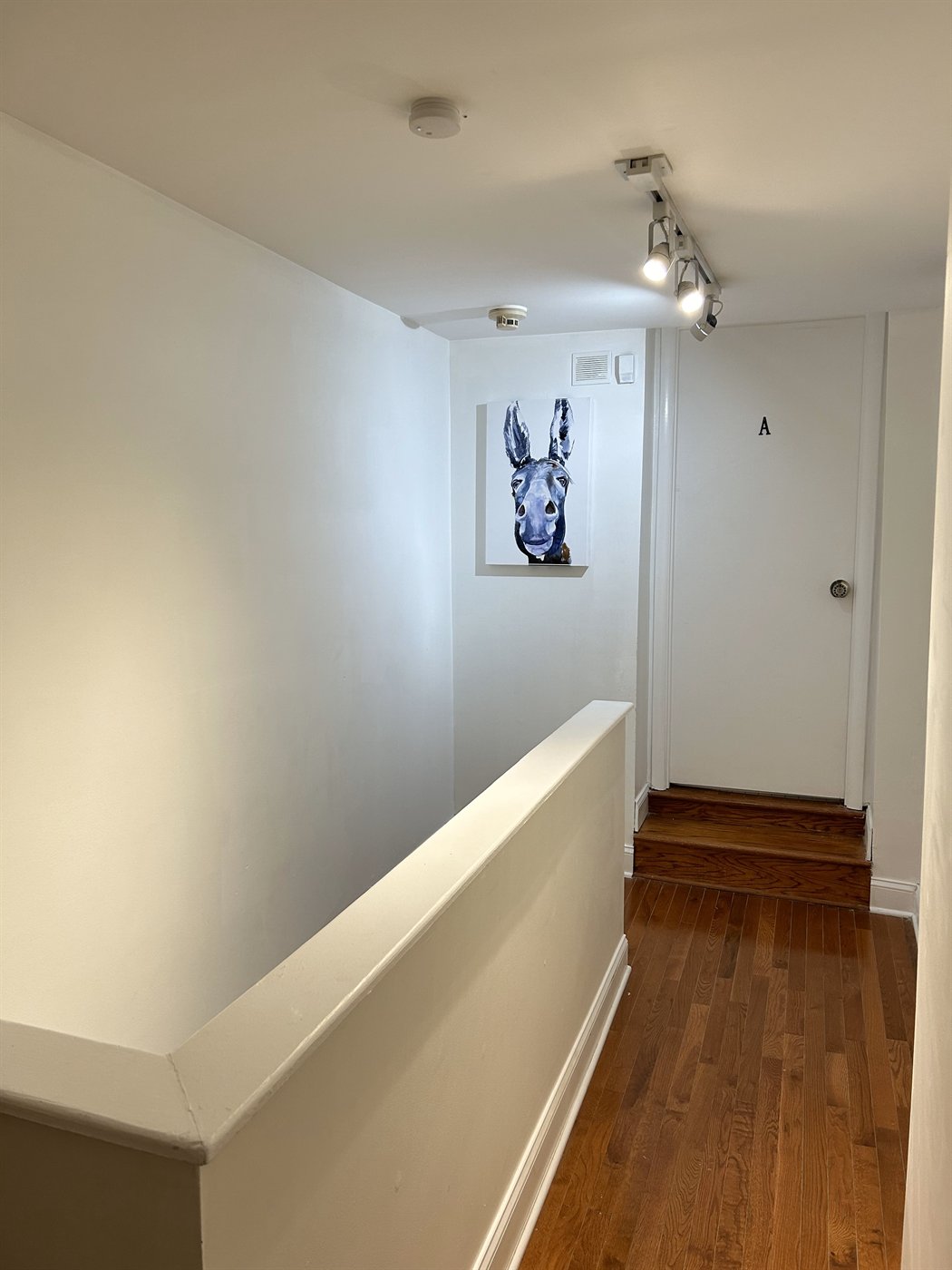 Upstairs landing with hardwood floors and a door marked A