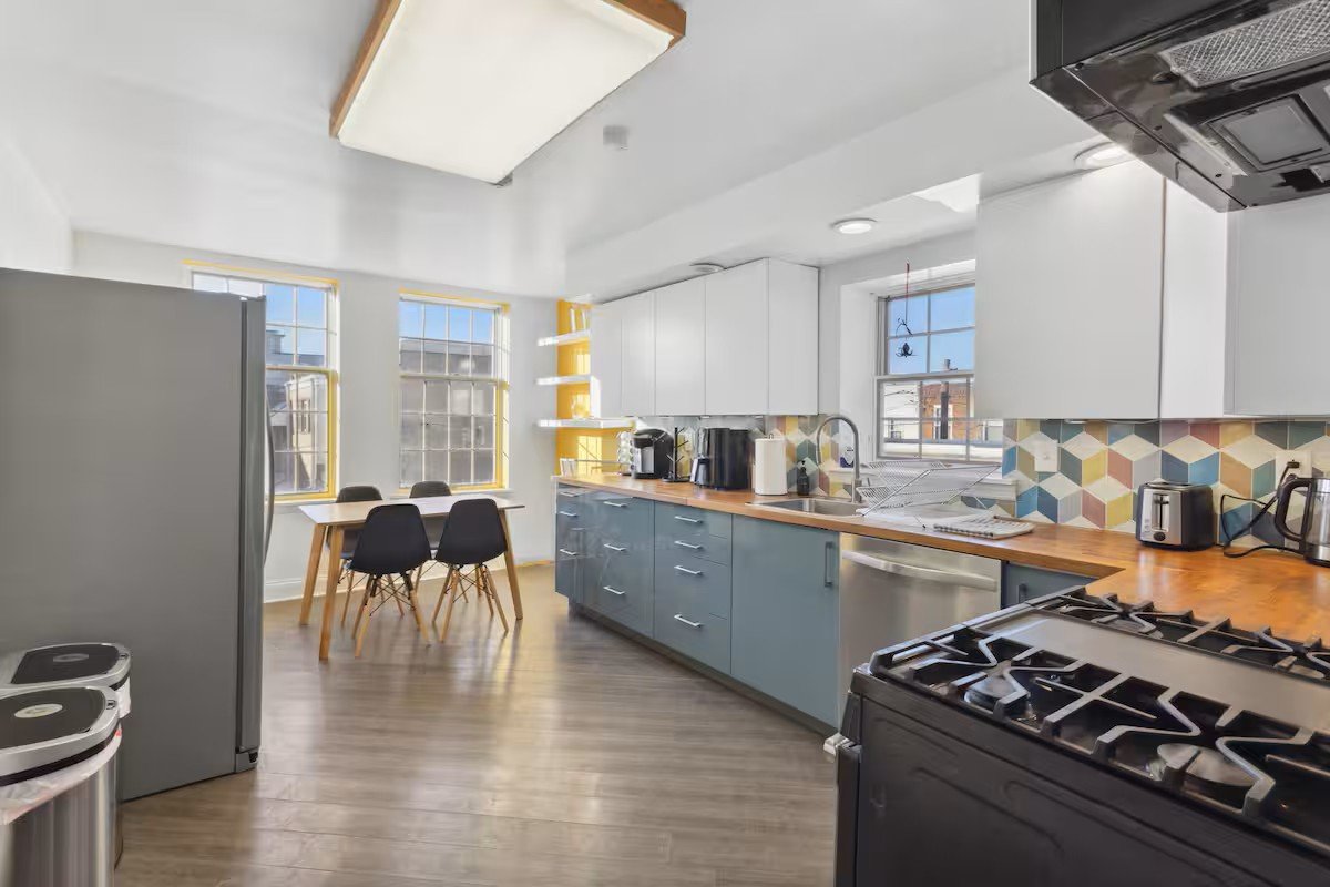 Kitchen and dining area with wood counters and yellow-framed windows