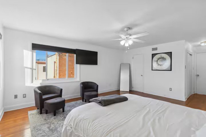 Master bedroom sitting area with windows and a television
