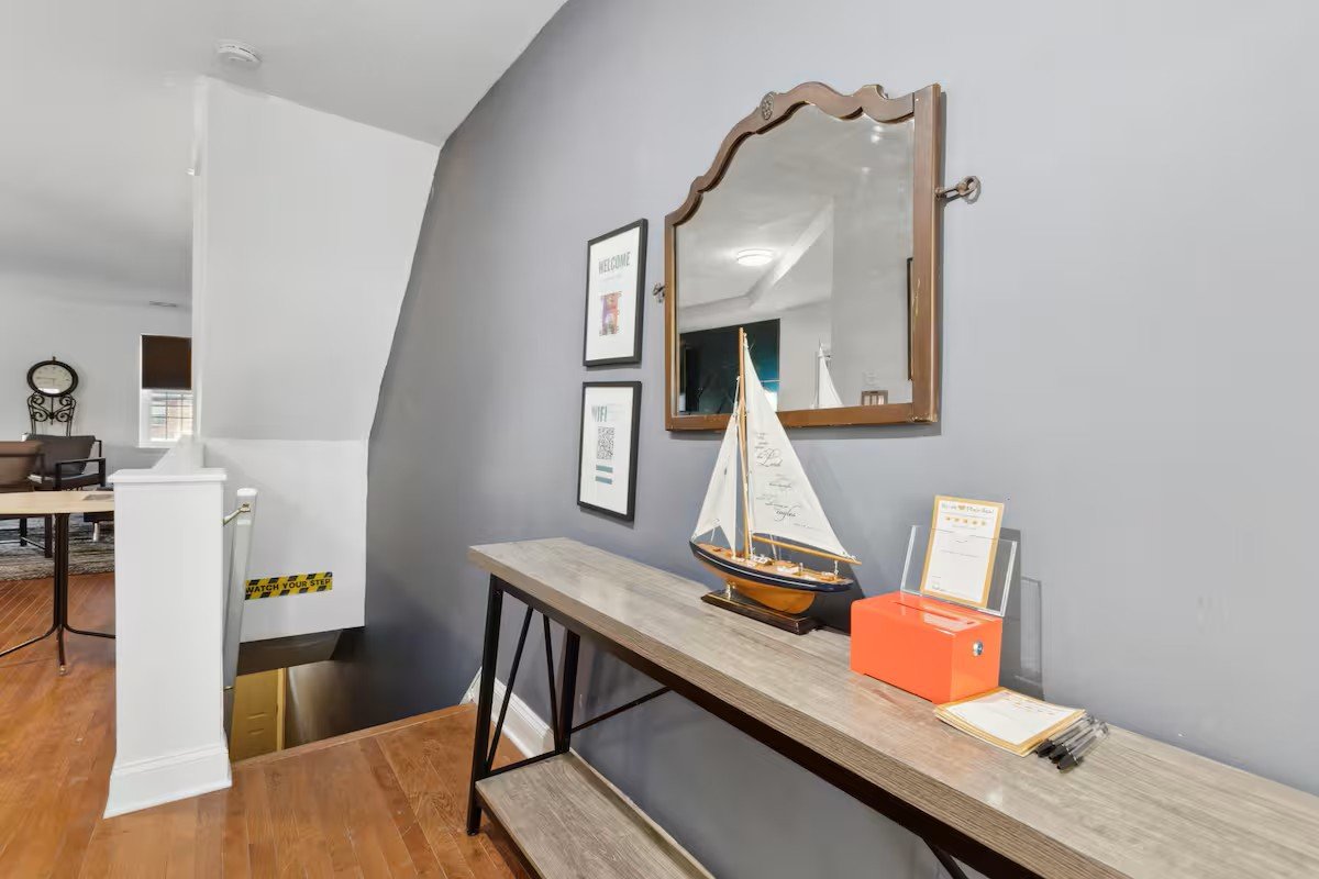 Entry stairwell with console table, sailboat, and welcome signs